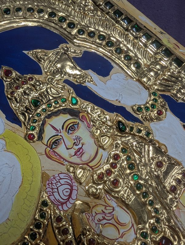 Faces and background being painted in colour around the gold