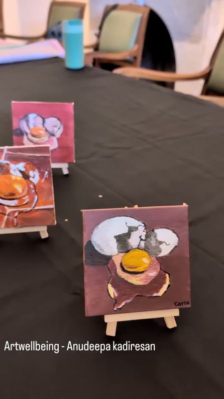 Small canvases of a broken egg on easels