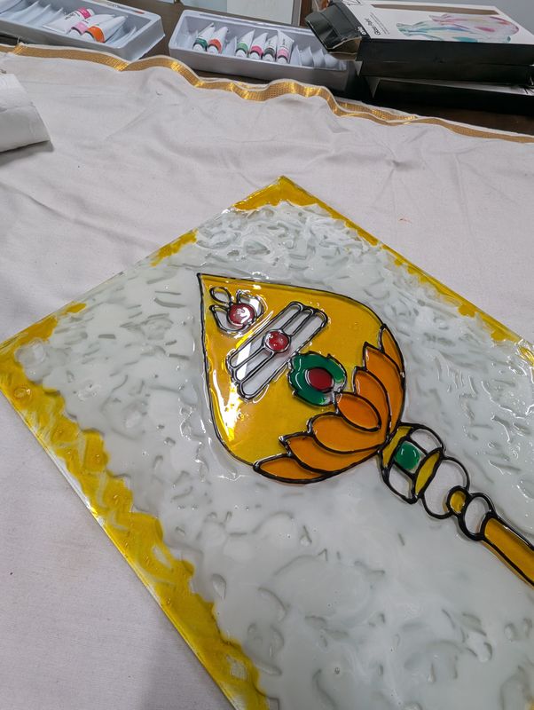 Glass painting of the Vel spear with sacred ash marks